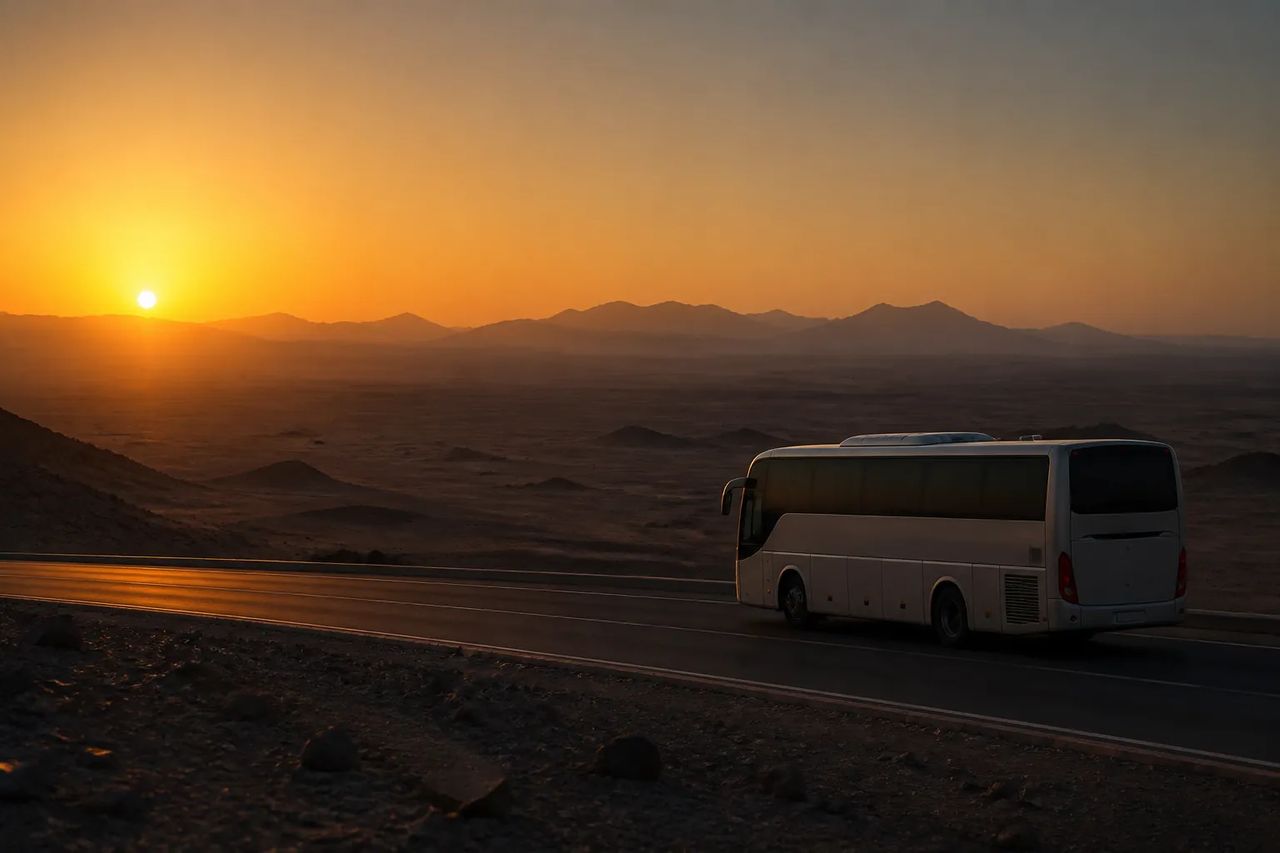 A modern Egyptian tourist coach on a desert highway at golden hour
