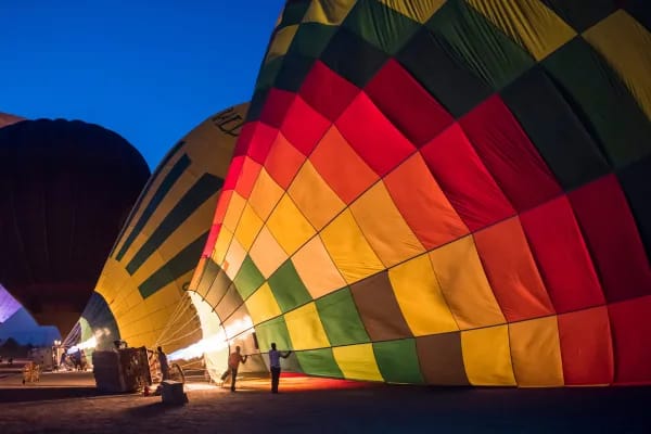 Colourful hot air balloon being inflated before a dawn flight in Luxor