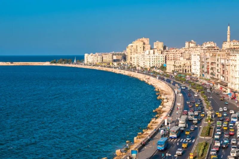 Curving Alexandria corniche along the Mediterranean with traffic and seafront buildings