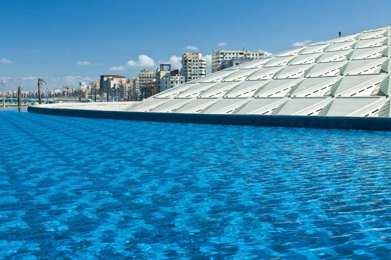 Roof of the Bibliotheca Alexandrina beside a blue reflecting pool
