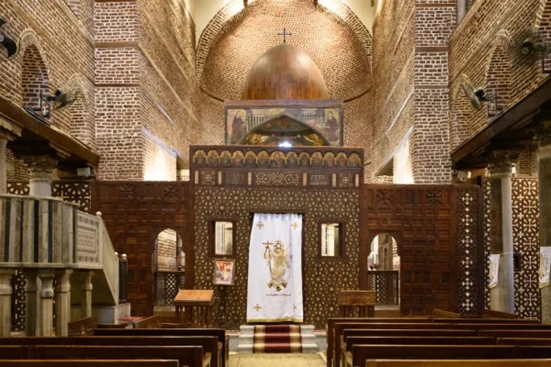 Interior of a Coptic church in Cairo with carved wooden screens and a domed ceiling