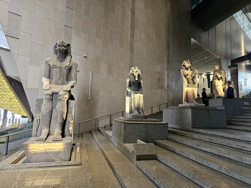 Colossal royal statues on the Grand Staircase inside the Grand Egyptian Museum