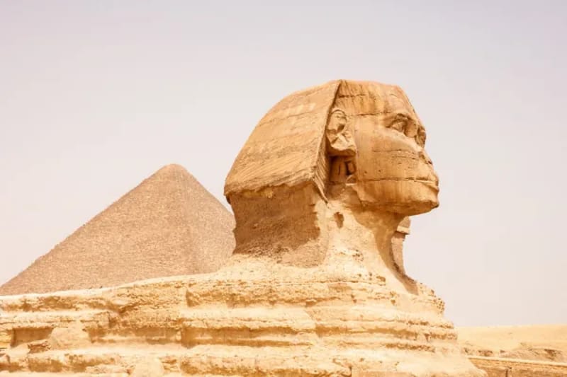 Close view of the Great Sphinx with a pyramid behind it