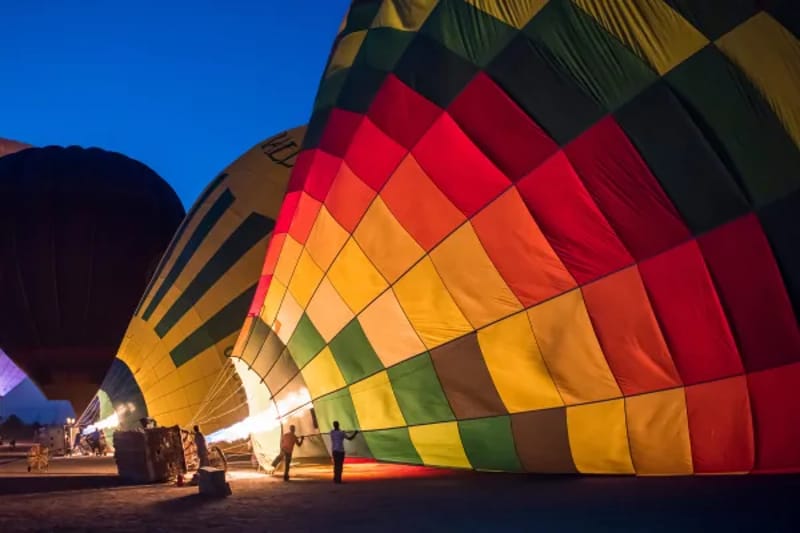 Colourful hot air balloon being inflated before a dawn flight in Luxor
