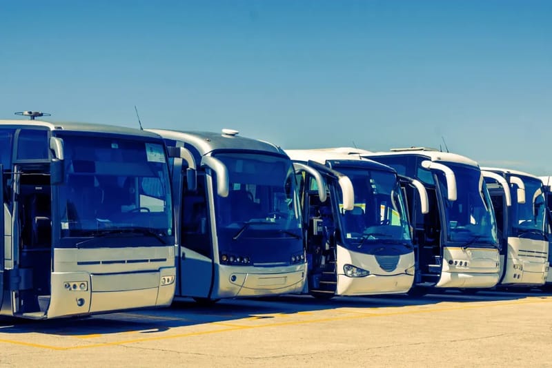 Row of blue touring coaches parked in a line