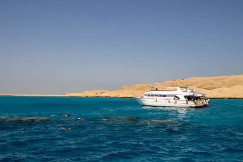 Day boat anchored in blue water off the Giftun islands