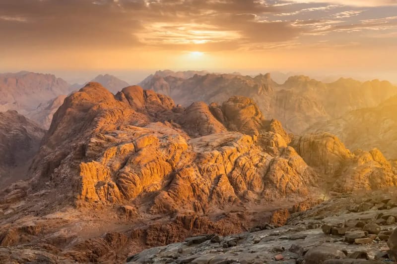 Granite peaks of the Mount Sinai area lit orange at sunrise